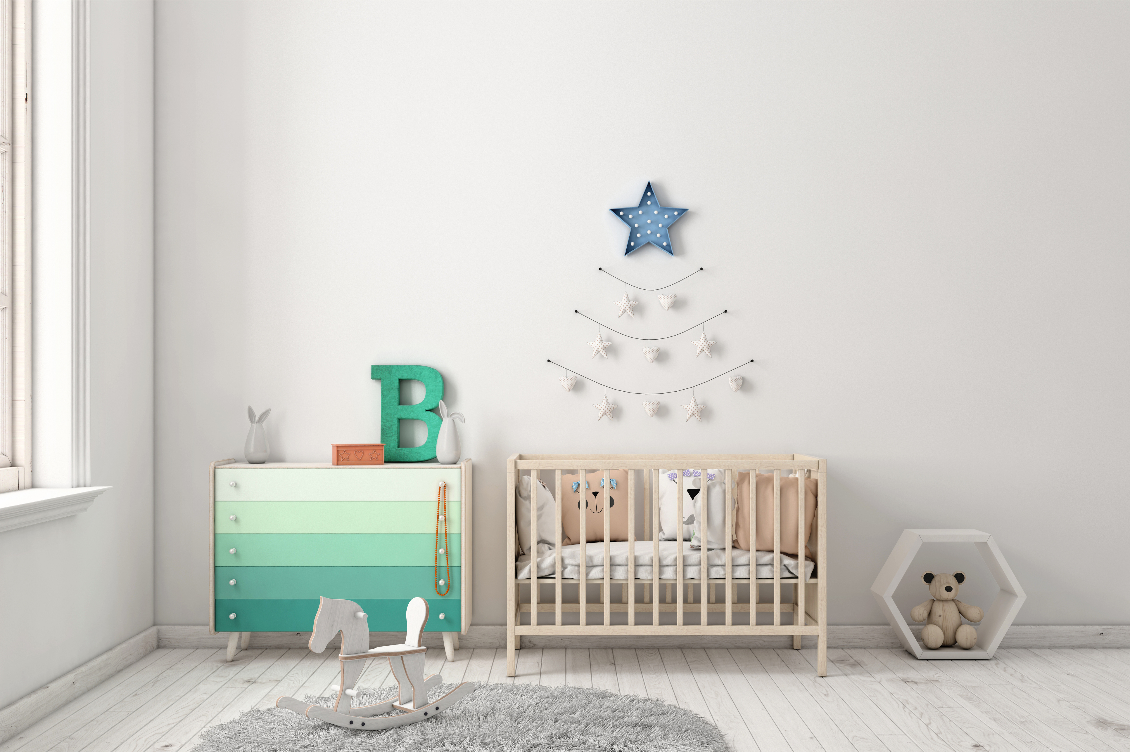 Clean nursery with a crib and soft green dresser